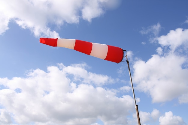 Windsackflagge mit roten und weißen Streifen auf blauem Himmelshintergrund sky