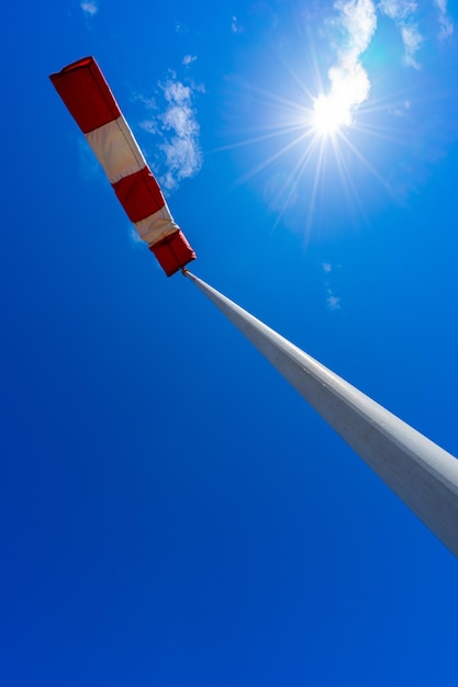 Windsocke in Betrieb mit starkem blauen Himmelhintergrund mit Sonne