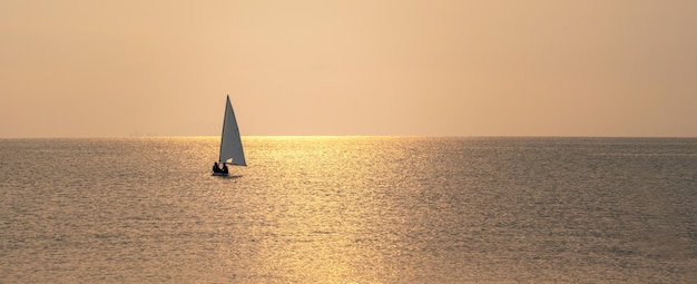 Windsurfen bei Sonnenuntergang schöne Aussicht auf das goldene Meer Goldenes Meer bei Sonnenuntergang mit Windsurfbrett Windsurfen bei Sonnenuntergang Windsurfen bei Sonnenuntergang