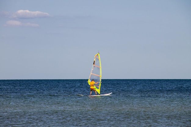 Windsurfen Surfer, der in ruhiger See oder im Ozean trainiert