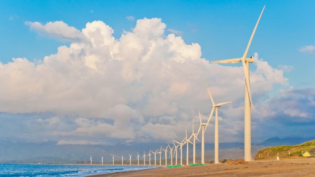 Windturbinen am Strand gegen bewölkten Himmel