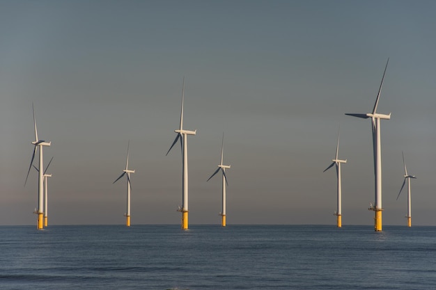 Windturbinen im Meer gegen den Himmel bei Sonnenuntergang