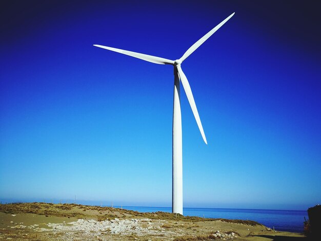 Foto windturbinen in der landschaft vor klarem blauen himmel