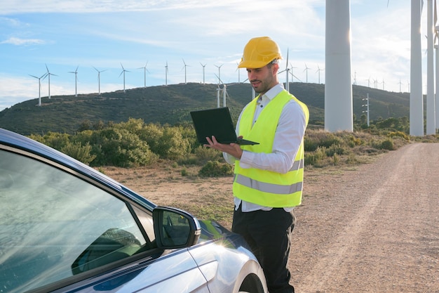 Windturbinenarbeiter mit Laptop und Auto