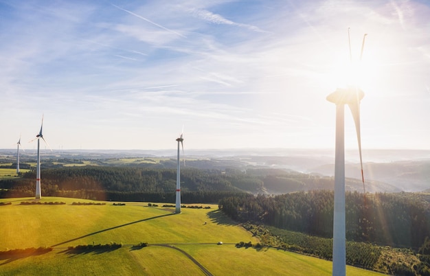 Windturbinenfarm und Landschaft an einem Sommertag - Energieerzeugung mit sauberer und erneuerbarer Energie - Drohnenaufnahme aus der Luft