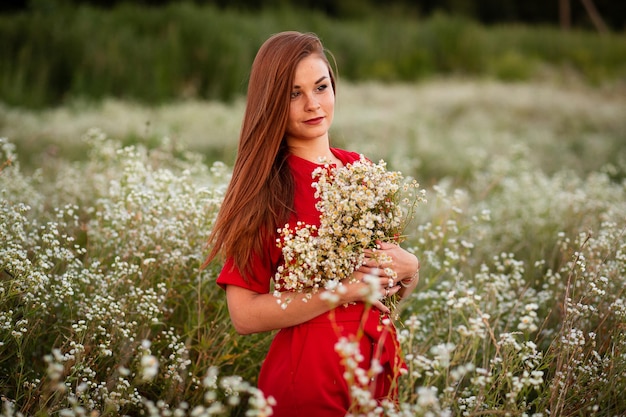 Winnyzja Ukraine 18. Juni 2021 Porträt eines Mädchens mit Sommersprossen und roten Haaren im Sommer auf einem Kamillenfeld mit einem Korb