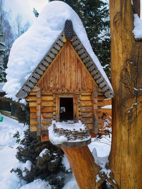 Foto winter avian retreat houseshaped bird feeder em um ramo nevado no parque