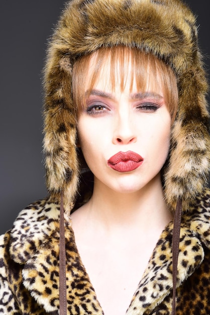 Winter-Frau im Luxus-Pelz-Mantel und im Hut Schönheits-Mode-Modell-Mädchen im Leoparden-Pelz-Mantel-perfektes Make-up Schöne Luxus-Winter-Dame
