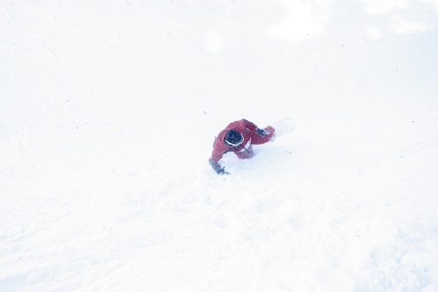 Winter-, Freizeit-, Sport- und Menschenkonzept - Snowboarder stürzte in den Schnee. Snowboarder fällt auf Neuschnee
