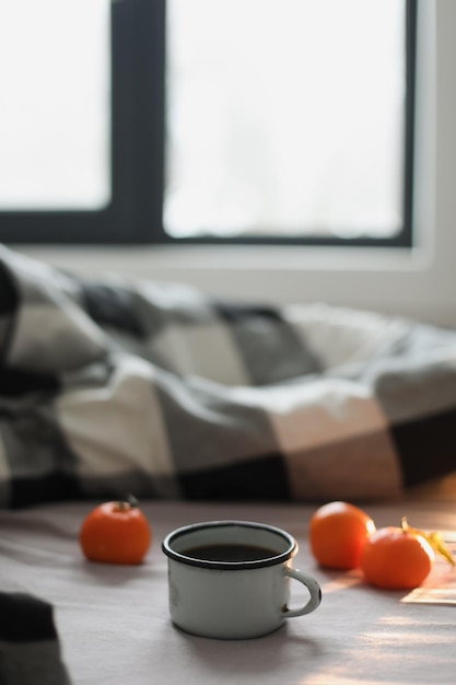 Winter gemütliches Konzept Tasse mit Kaffee und Mandarinen auf dem Bett Kopierbereich Flache Draufsicht