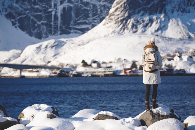 Winter. Mädchen geht am Ufer des Fjords entlang. Lofoten-Inseln. Norwegen