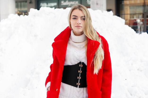 Winter, Mode, Menschen Konzept - Mode Porträt einer schönen jungen Frau geht durch die Stadt lächelnd roten Pelzmantel Nahaufnahme Schneeflocken kalten Winter, frische Luft am Frost Wintertag atmen