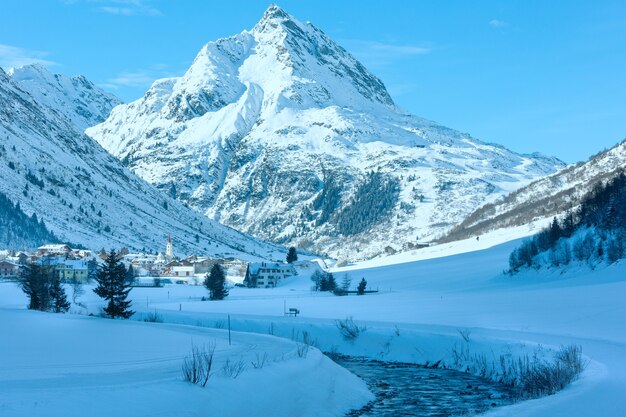 Winter Mountain Stream View und Dorf im Tal (Österreich).