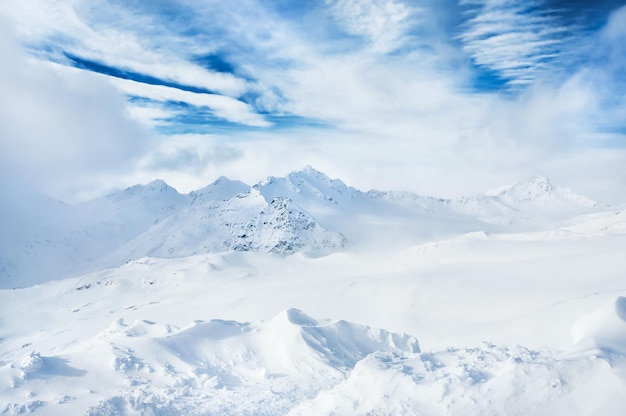 Winter schneebedeckte Berge und blauer Himmel mit weißen Wolken. Schöne Winterlandschaft