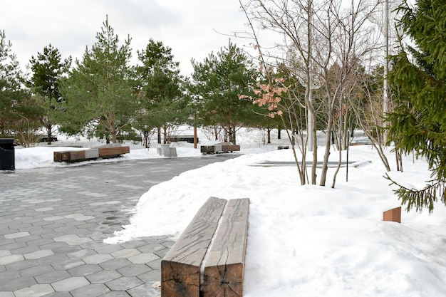 Winteransicht des Zaryadye-Parks Große Holzbänke in einem verschneiten Park