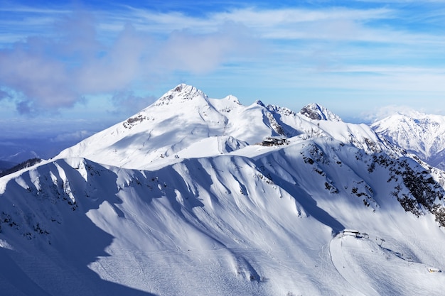 Winterberg und blauer Himmel mit schönen Wolken. Harte Schatten fallen auf Berggipfel. Naturlandschaften in Russland.