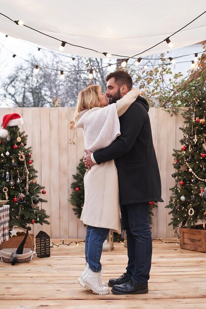 Winterferien und Feiern Verliebtes Weihnachtspaar in der Nähe des Weihnachtsbaums im Freien