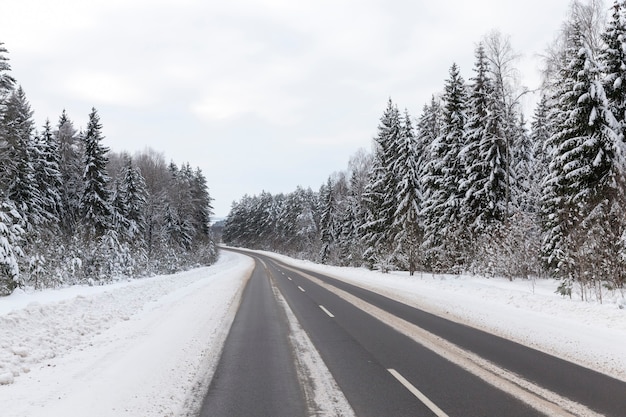 Wintergepflasterte straße für fahrzeuge, winterzeit bei schneewetter