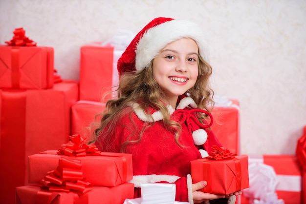 Winterglück Konzept. Entdecken Sie Weihnachtsgeschenke. Weihnachtsgeschenk auspacken. Feiertagstradition des neuen Jahres. Kind aufgeregt über das Öffnen des Weihnachtsgeschenks. Mädchen feiern Weihnachten. Der Weihnachtsmann bringt ihr Geschenk.