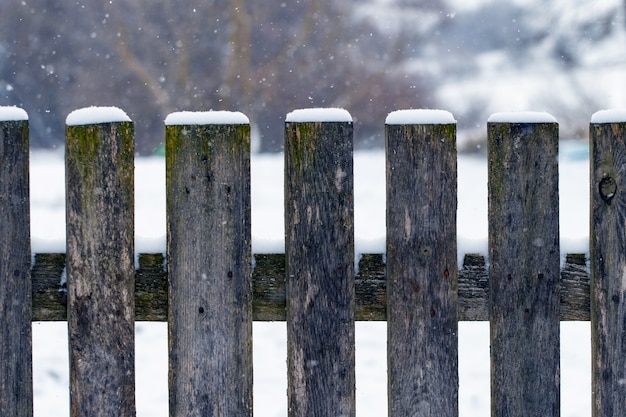 Winterhintergrund mit einem schneebedeckten Holzzaun