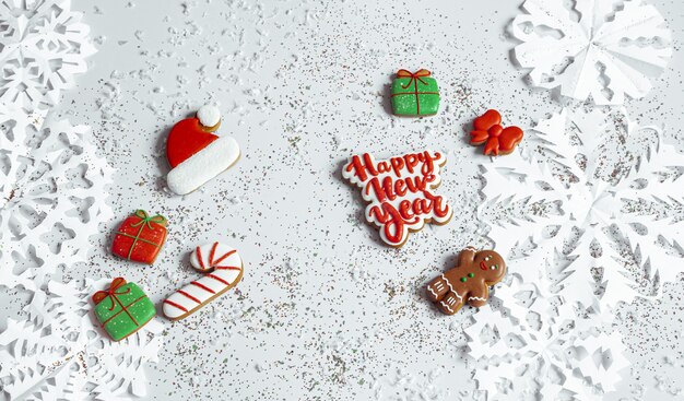 Winterhintergrund mit verziert mit Glasurlebkuchen, Schneeflocken und Konfetti Draufsicht. Frohes neues Jahr und Weihnachtskonzept.