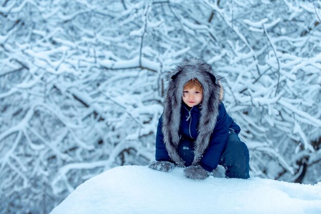 Winterkind posiert und hat Spaß in der Kindheit auf dem Land Kinder laufen auf schneebedeckten Feldern Kinder haben Spaß ...