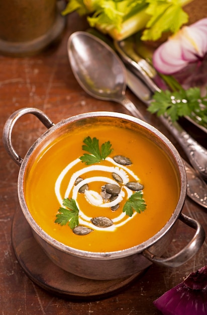 Winterkochen, gesundes Essen. Kürbissuppe auf rustikalem hölzernem Hintergrund