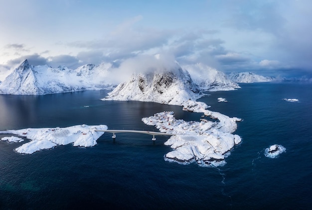 Winterlandschaft aus der Luft Luftaufnahme des Dorfes Hamnoy Lofoten Norwegen Landschaft während der blauen Stunde Berge und Wasser Reisebild