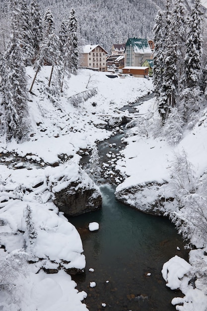 Winterlandschaft Bergfluss fließt zwischen Felsen im Schnee Nadelwald Frost auf Ästen starker Schneefall