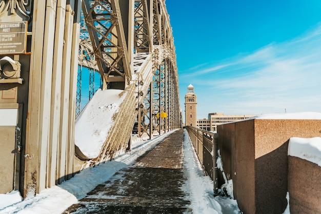 Winterlandschaft der Bolschewhtinski-Brücke in St. Petersburg an einem sonnigen verschneiten Tag