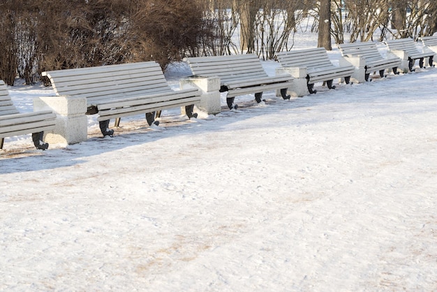 Winterlandschaft des Parks und Bank zum Ausruhen