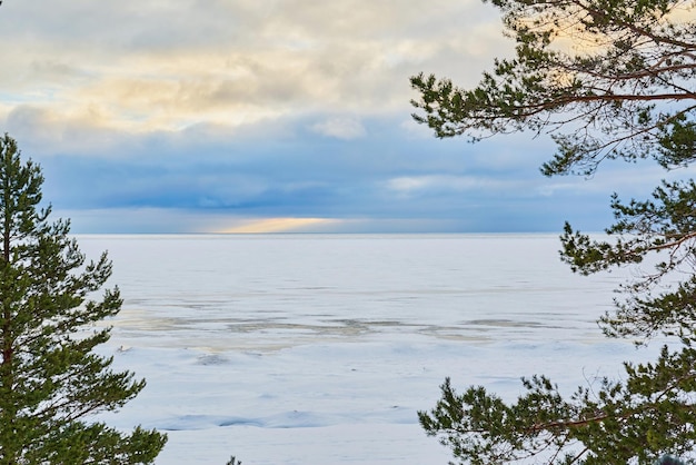 Winterlandschaft eines großen schneebedeckten Sees und bewölkter Himmel am Horizont