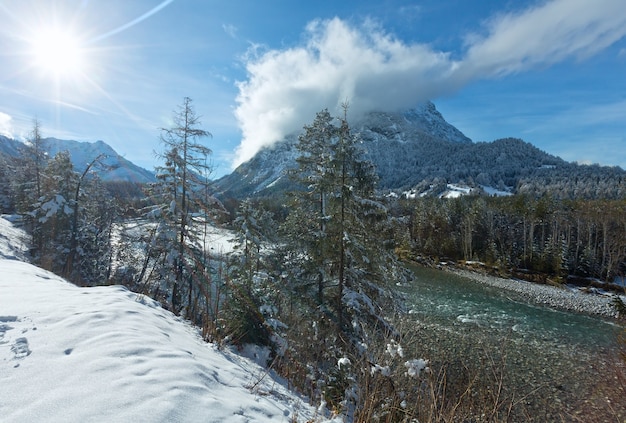 Winterlandschaft mit Berg und Fluss (Österreich, Tirol)