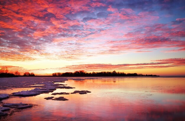 Winterlandschaft mit brennendem Himmel des Sonnenuntergangs. Zusammensetzung der Natur.