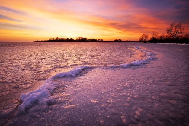 Winterlandschaft mit brennendem Himmel des Sonnenuntergangs. Zusammensetzung der Natur.