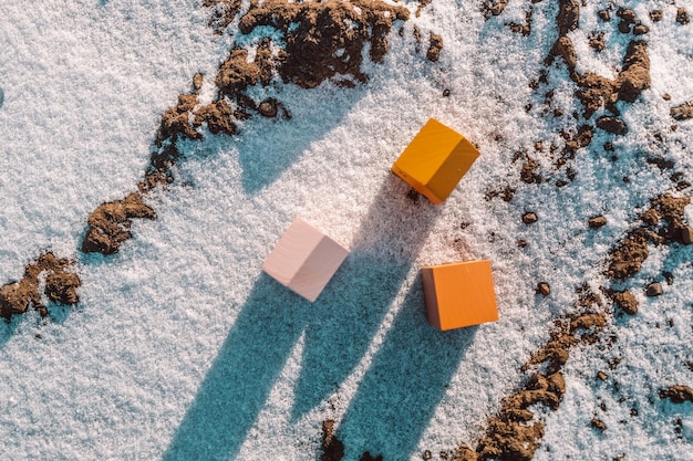 Winterlandschaft mit Miniaturmodell von Holzhäusern mit Sonnenlicht auf Winterschneehintergrund nach Hause ...