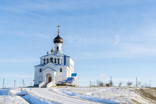 Winterlandschaft mit orthodoxer Kirche und strahlend blauem Himmel am hellen Wintertag