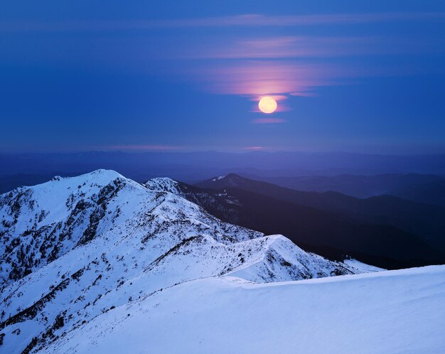 Winterlandschaft mit Vollmond in den Bergen