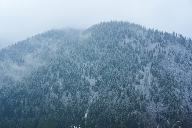 Winterliche Berglandschaft. Kleine Stadt zwischen Bergen. Über der Stadt hängt eine Wolke.