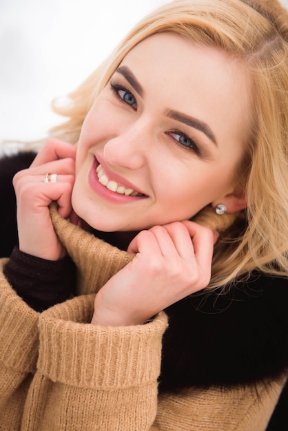 Wintermädchen Spaß, schöne Blondine auf dem Schnee