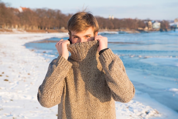 Wintermode. warmer Pullover. Sexy Mann in warmer Kleidung. Warme Kleidung für die kalte Jahreszeit. Schöne Winterferien. Grippe und Erkältung. Mann, der im Winter reist, Natur. Vorbereitung auf den Winter.