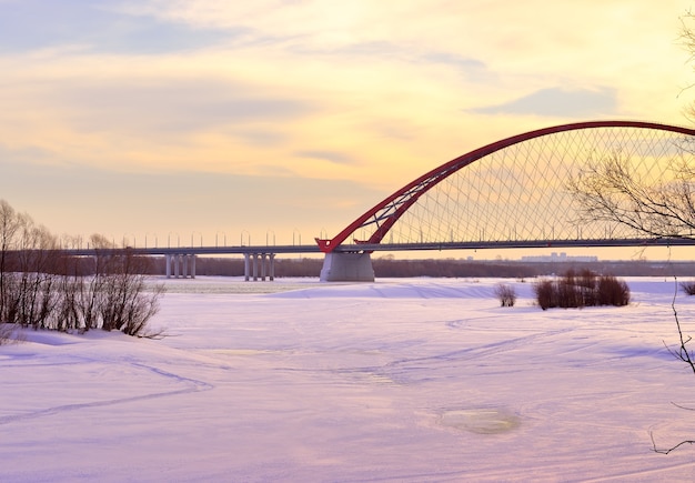 Wintermorgen auf dem Ob Der Bogen der Bugrinsky-Autobrücke auf dem zugefrorenen Fluss