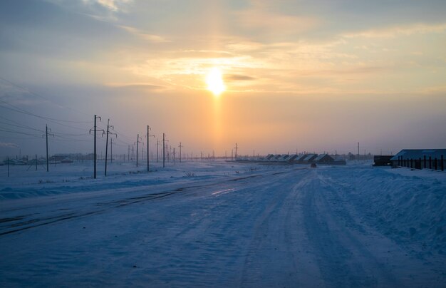 Wintermorgen verschneite Straße Morgensonne