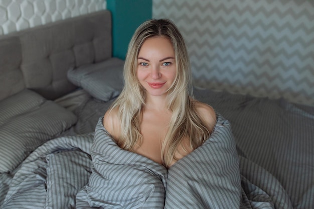 Wintermorgenein sexy Mädchen wickelte ihre Bettdecken in Bettwäsche und wachte früher zur Arbeit auf