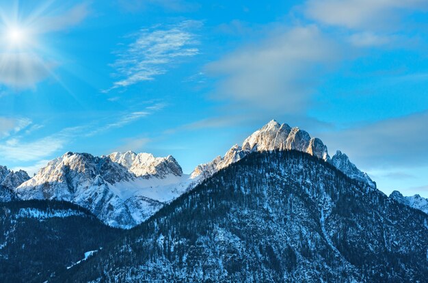 Wintermorgens sonnige Berglandschaft mit Wald am Hang (Österreich).