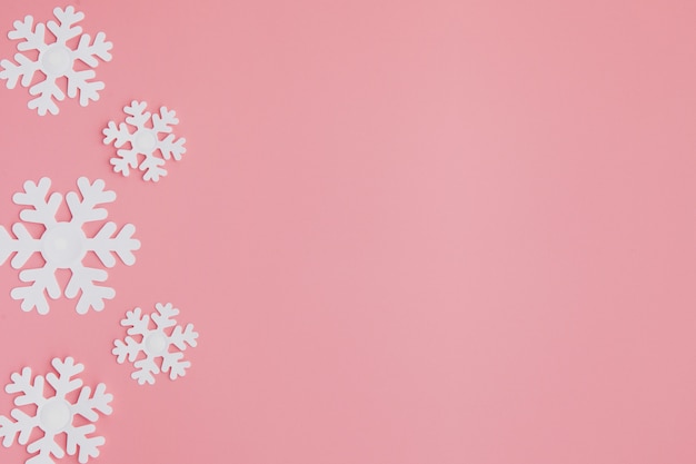 Wintermuster gemacht von den Schneeflocken und auf rosa Hintergrund.