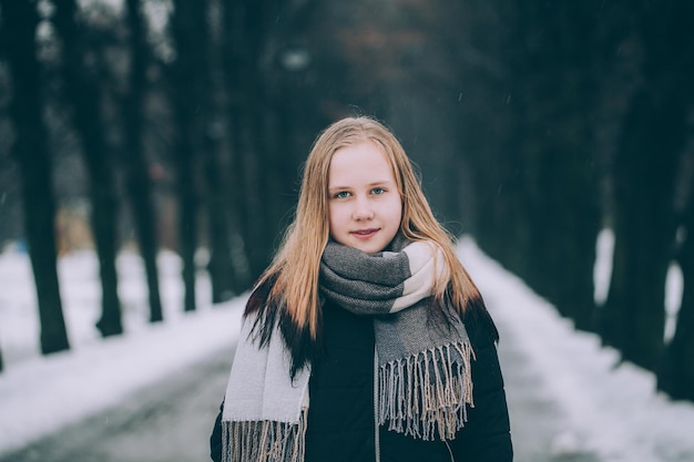 Winterporträt des netten Mädchens im Freien