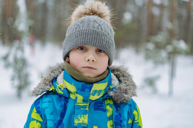 Winterporträt eines süßen kaukasischen Jungen an einem sonnigen Tag