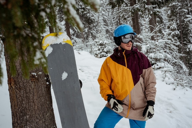 Wintersport und Erholung, Freizeitaktivitäten im Freien. Mann in Skiausrüstung, Schutzbrille tragend. Snowboardermann, der am Berg wandert.