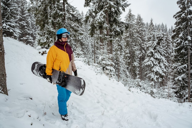 Wintersport und Erholung, Freizeitaktivitäten im Freien. Mann in Skiausrüstung, Schutzbrille tragend. Snowboardermann, der am Berg wandert.